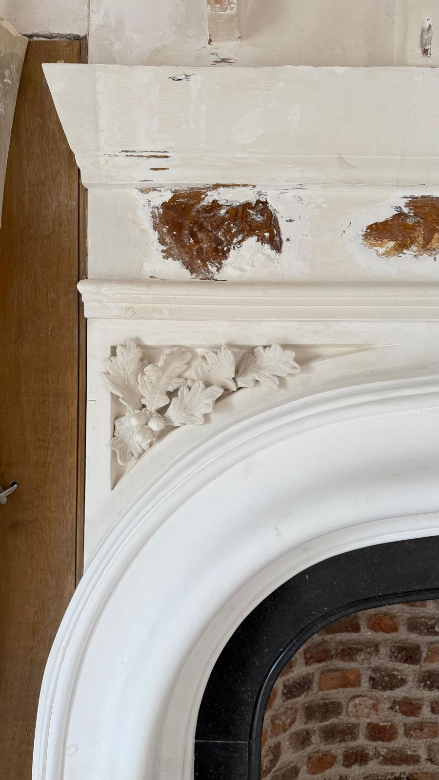 Plaster oak leaves above the arch of the fireplace