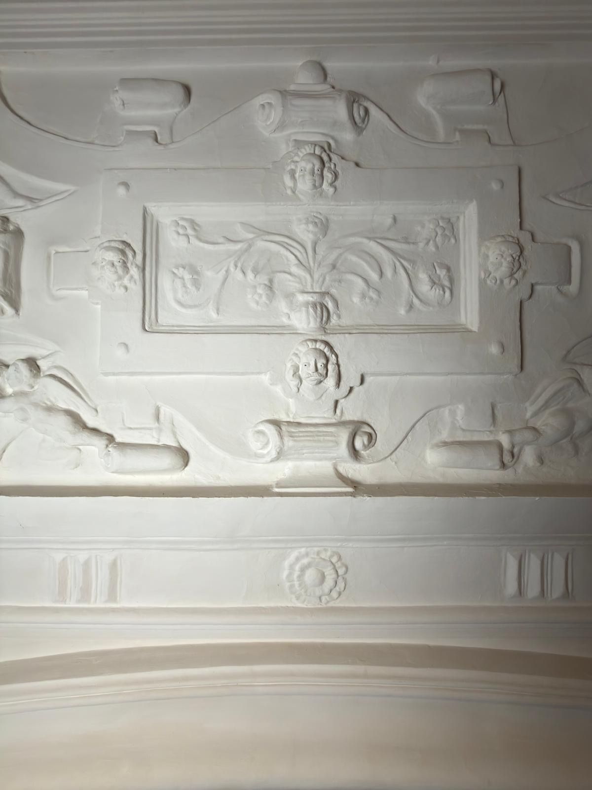 The plaster panel above the fireplace with the new frieze below