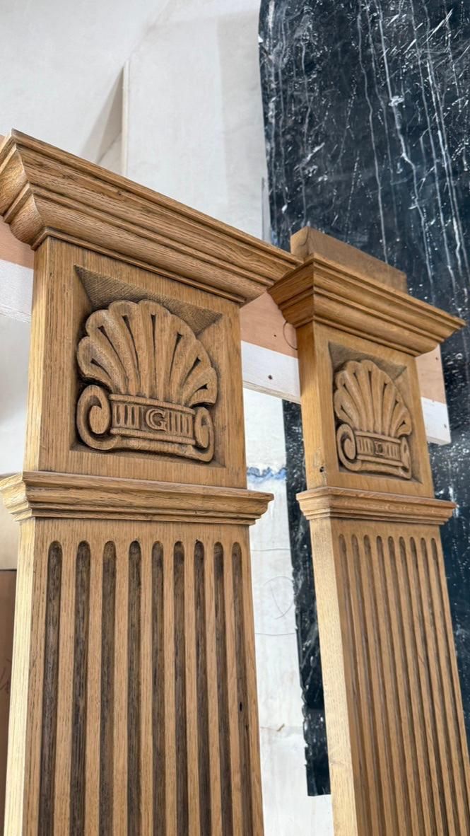 Two oak pilasters with carved scallop-shell capitals in the workshop